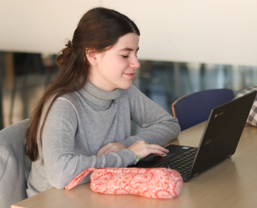 Alumna usando portátil en el aula de colegios privados bachillerato en Madrid.